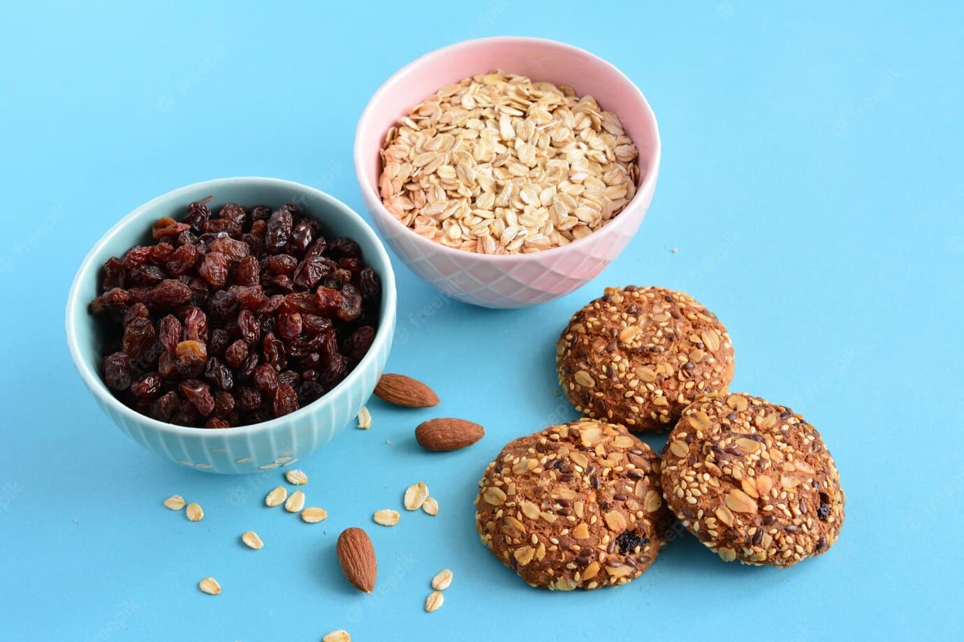blue-pink-bowls-with-raisin-oatmeal-oat-cookies-blue-background_715893-1161