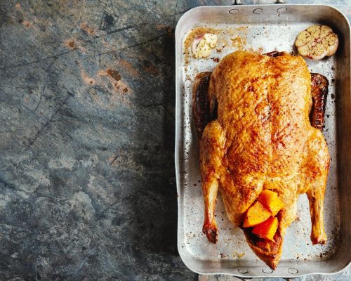 baked-roasted-duck-with-vegetables-pan-stone-background-top-view_1220-6620