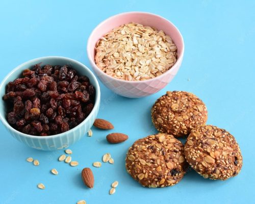 blue-pink-bowls-with-raisin-oatmeal-oat-cookies-blue-background_715893-1161