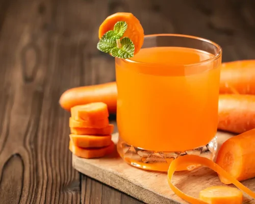 carrot-juice-glass-wooden-table_1150-18385