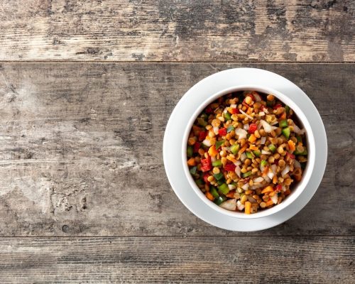 lentil-salad-with-peppersonion-carrot-bowl-wooden-table_123827-21421