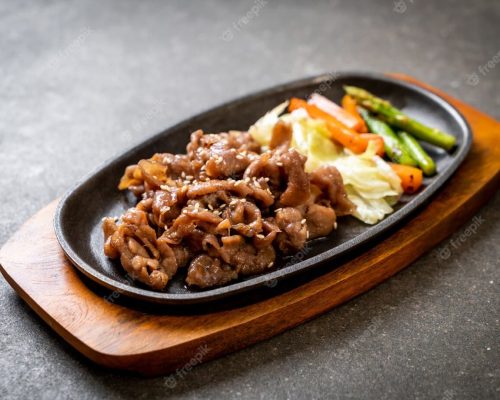 sliced-pork-steak-hot-plate_1339-39902